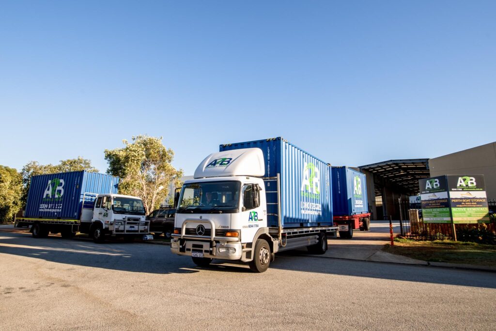 A2B Removals truck with blue containers parked outside an industrial warehouse, ready for a commercial relocation